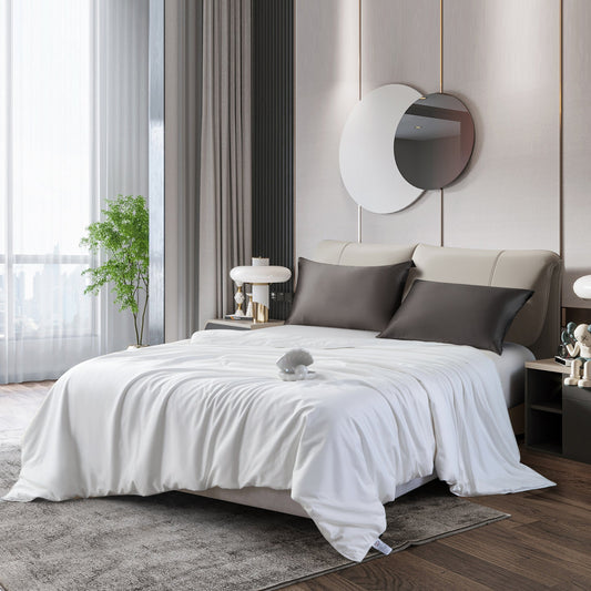 A made bed with a white duvet and two dark pillows