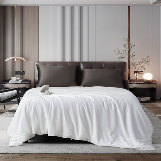 White duvet on a made bed with two dark pillows